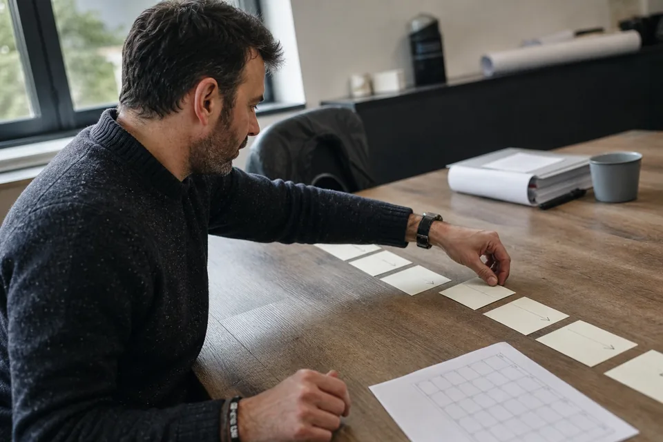 Sales lead arranging index cards as steps of a sequence on a table